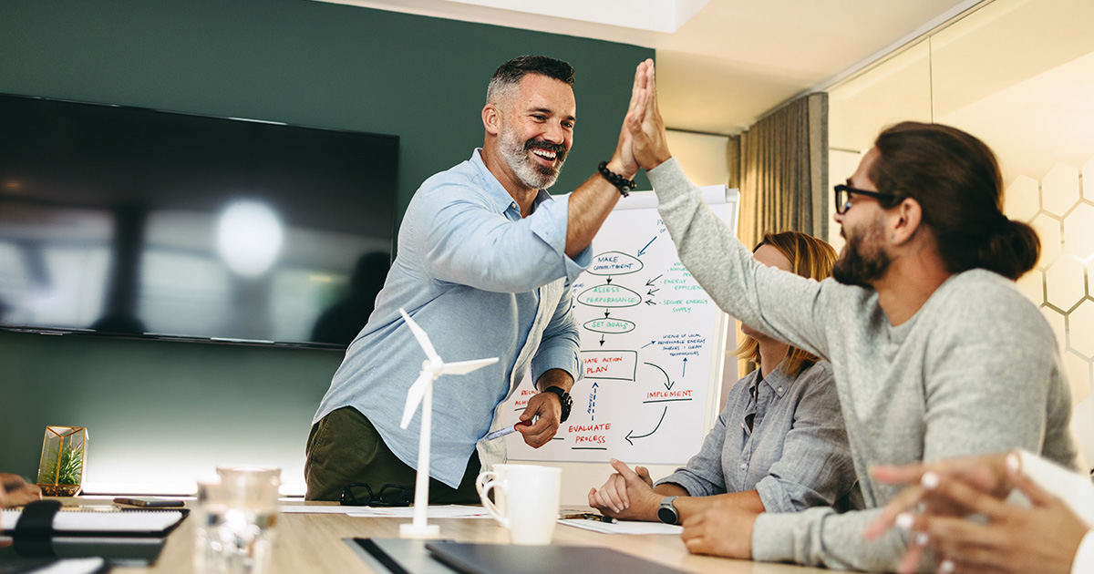 Erfolgreiche Geschäftsleute, die sich während eines Meetings gegenseitig abklatschen